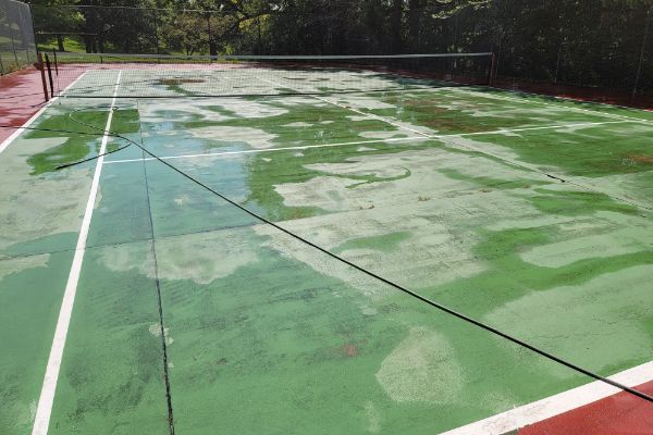 A tennis court with a green and red surface and a white line.