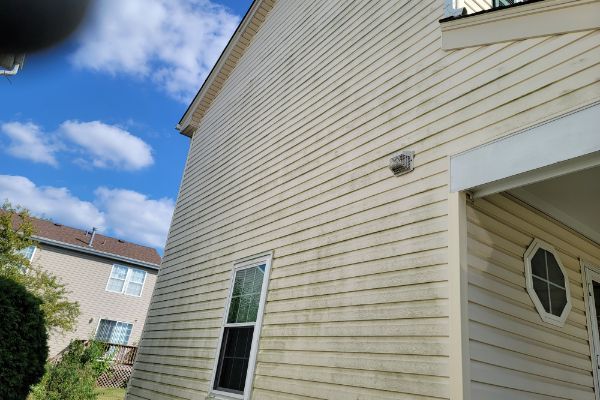 The side of a house with a lot of windows and a blue sky in the background.