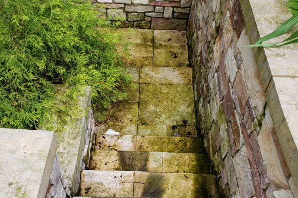 A set of stairs leading up to a stone wall.