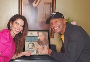 A man and a woman are standing next to each other in front of a piano.