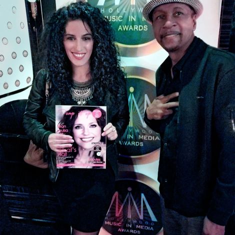 A man and a woman standing in front of a sign that says music in media awards