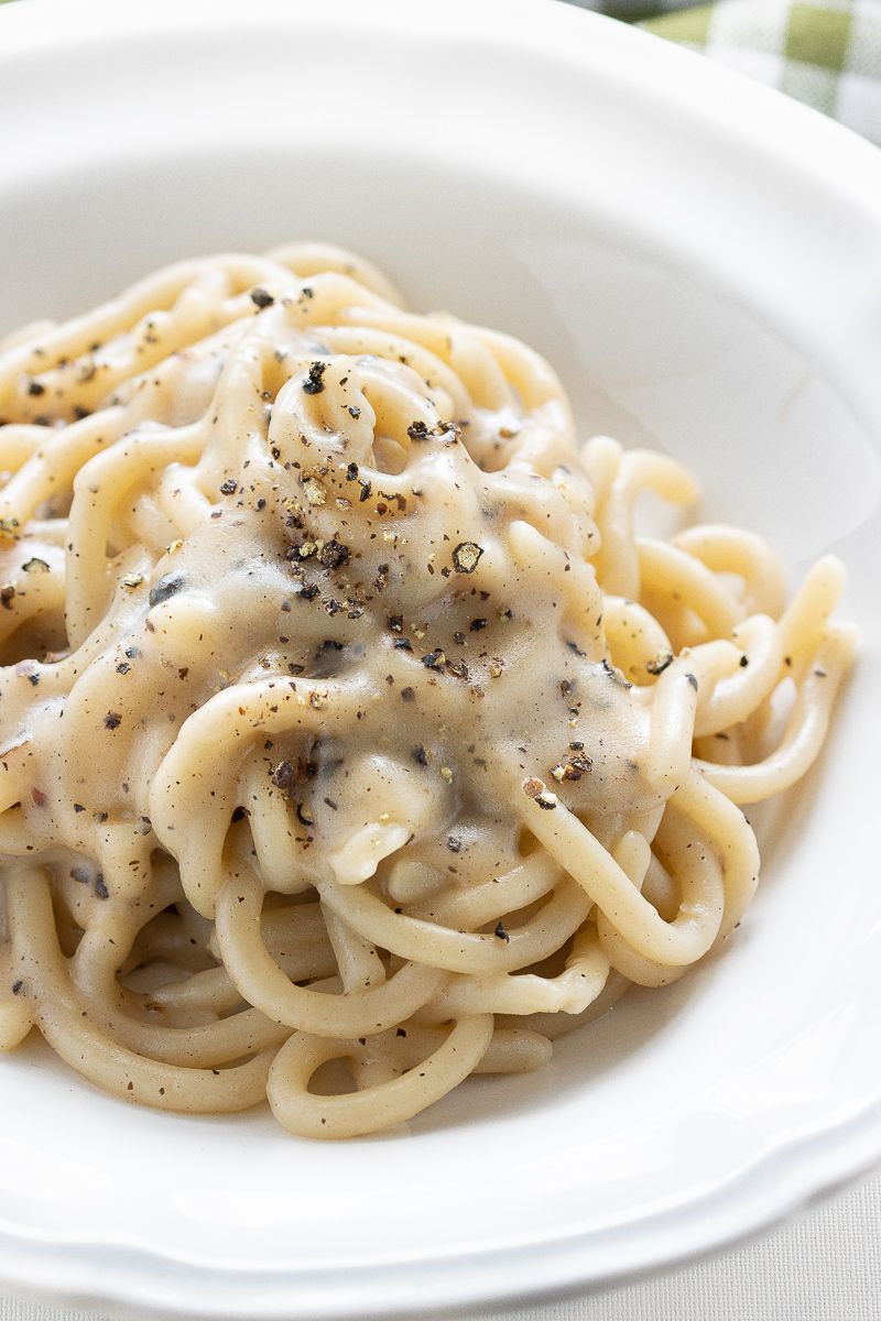Pasta cacio e pepe in una ciotola bianca, cosparsa di pepe nero.
