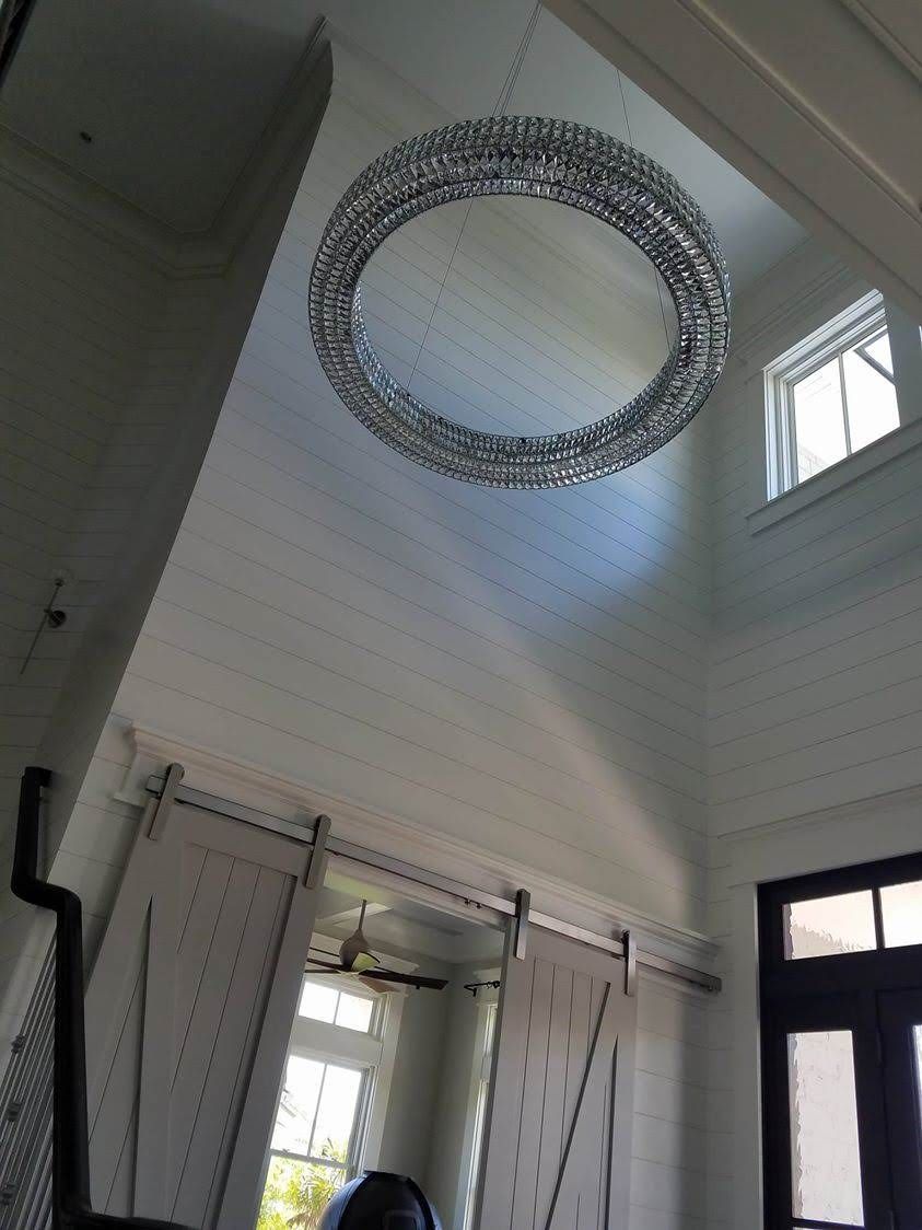 A room with a large mirror hanging from the ceiling