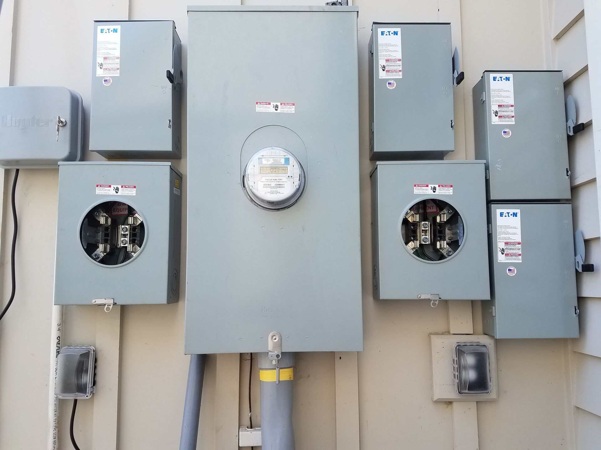 A row of electrical boxes on the side of a building.