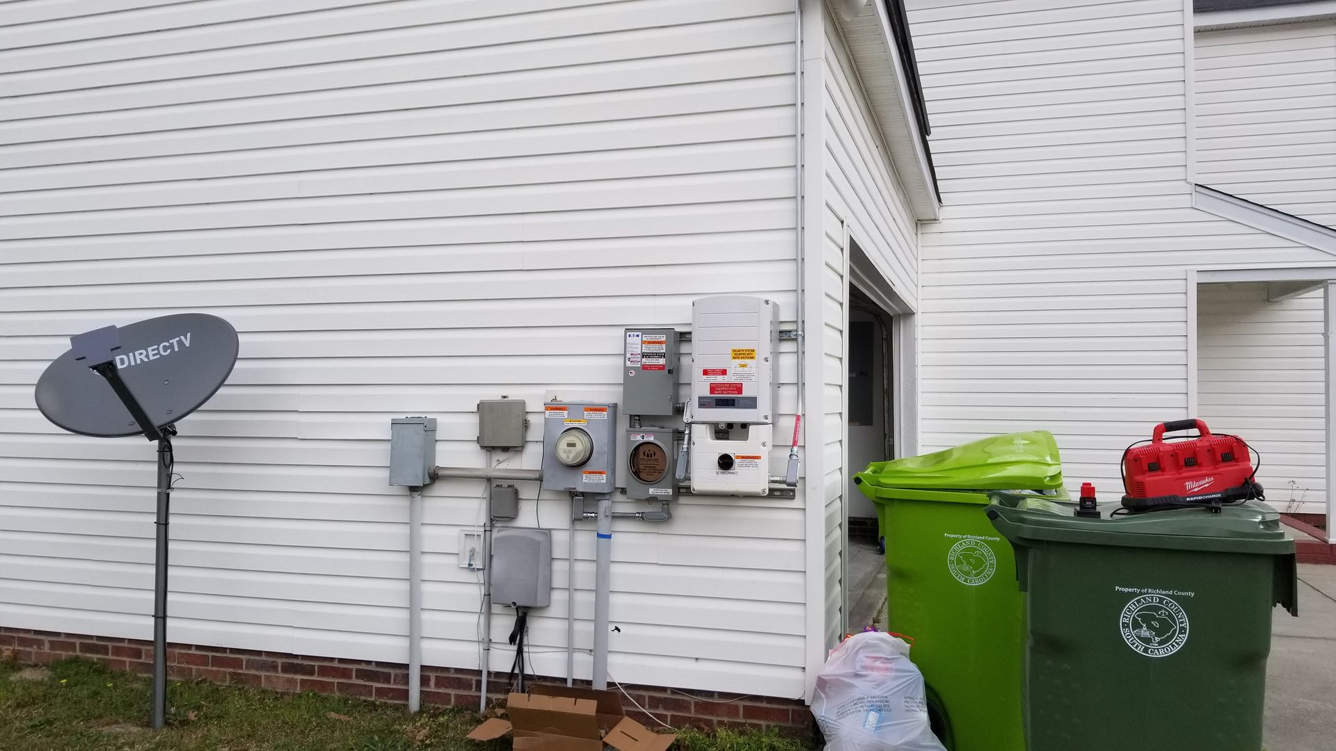 There is a satellite dish on the side of a house.
