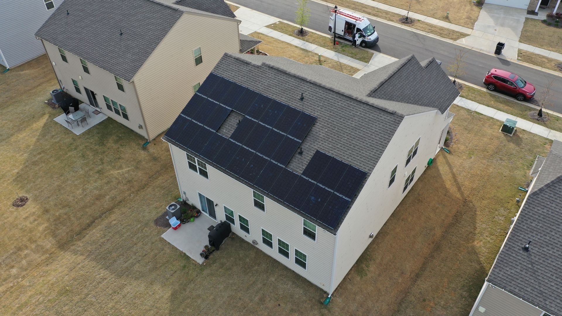 An aerial view of a house with solar panels on the roof.