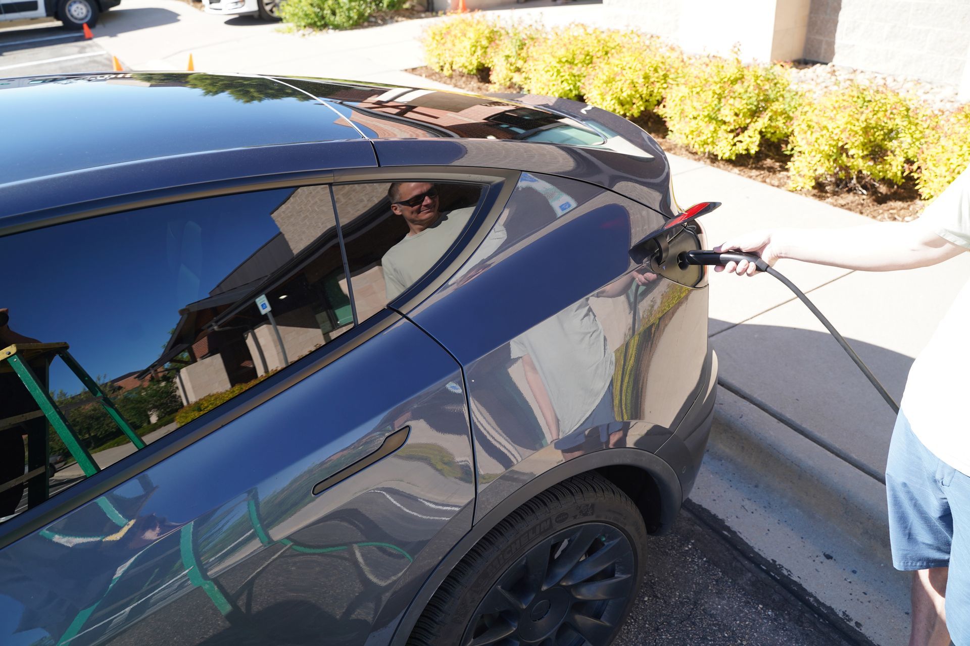 A person is charging a tesla model y in a parking lot