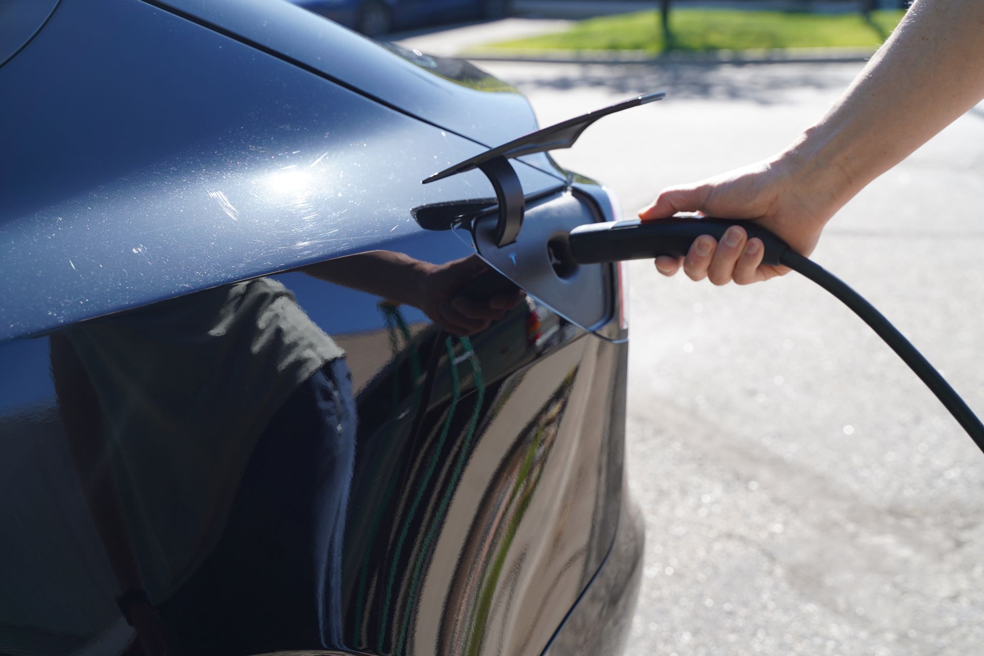 A person is charging an electric car with a charger
