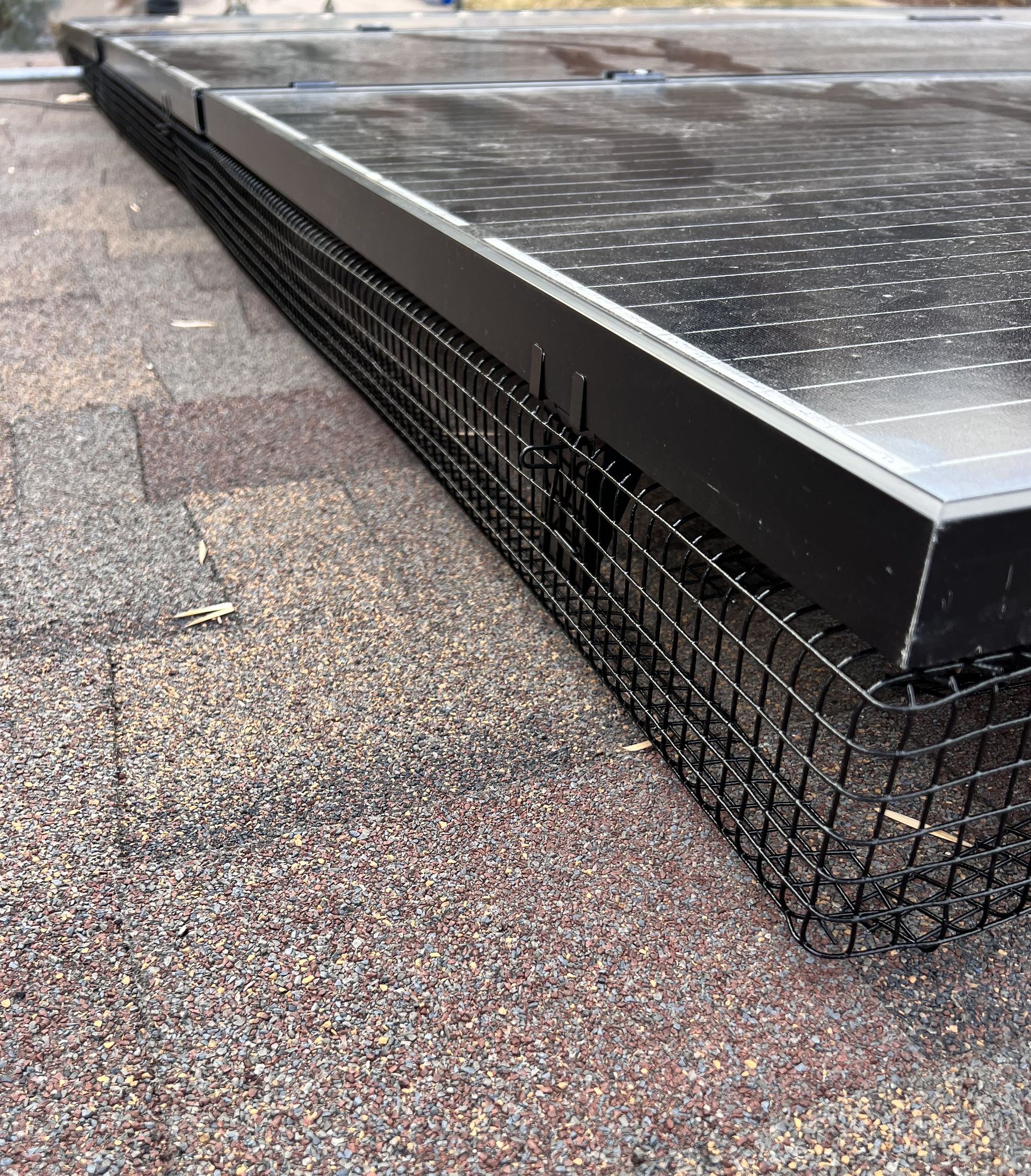 A solar panel is sitting on top of a roof with a fence around it.