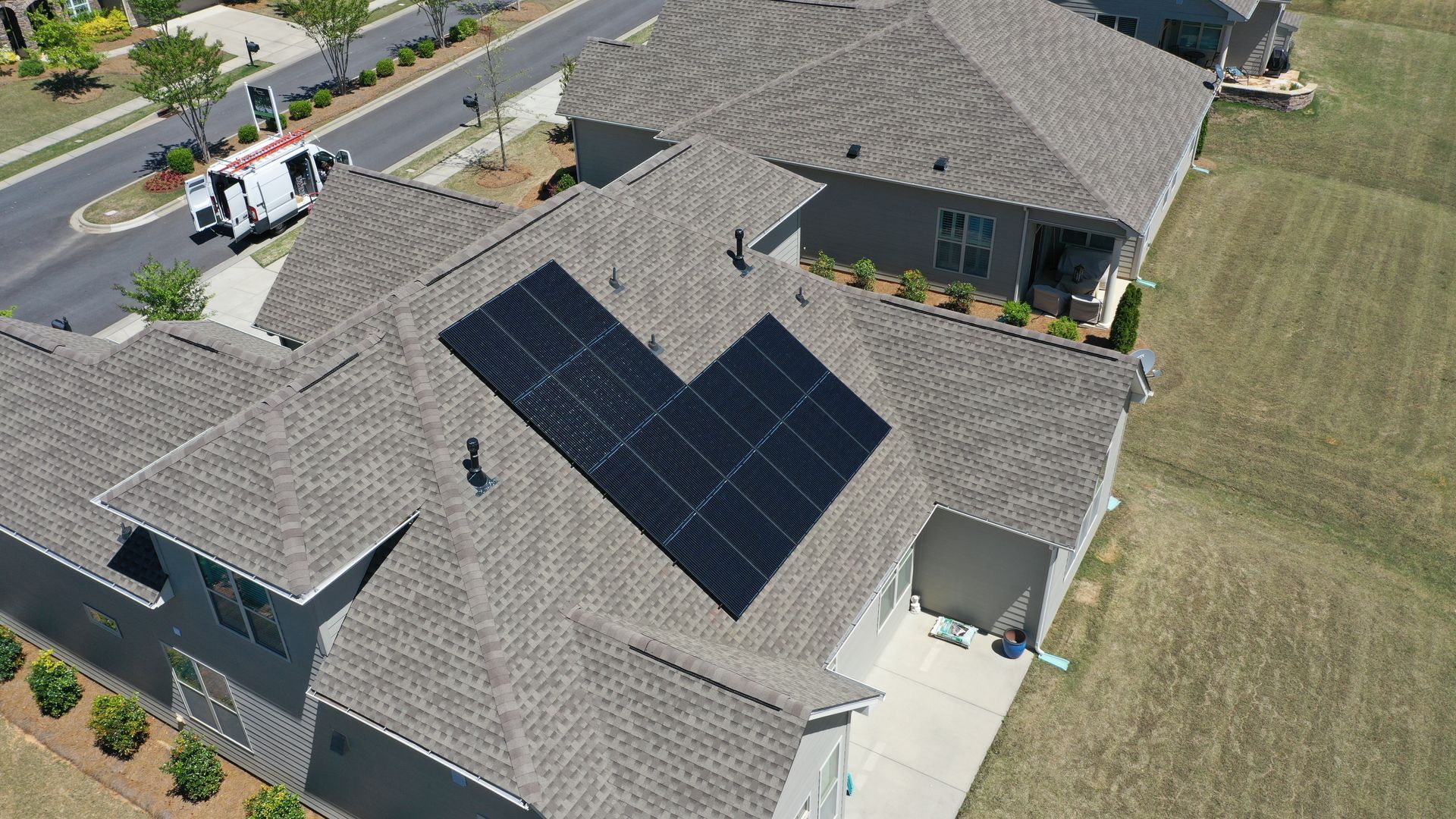 An aerial view of a house with solar panels on the roof.