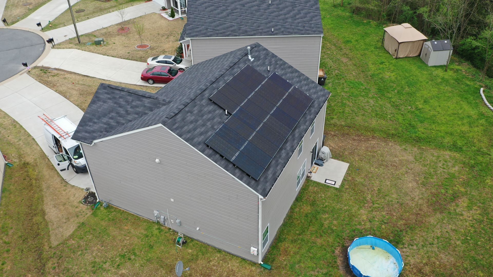 An aerial view of a house with solar panels on the roof.