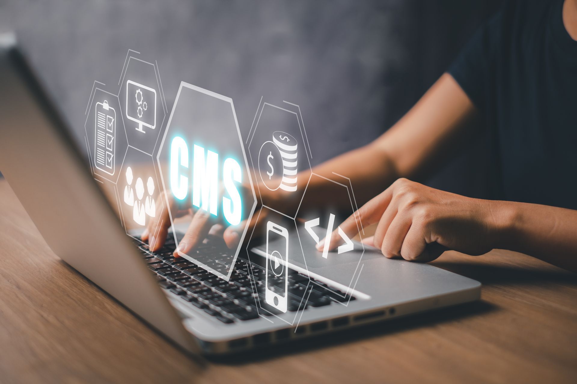 Person typing on laptop, CMS graphic overlay.