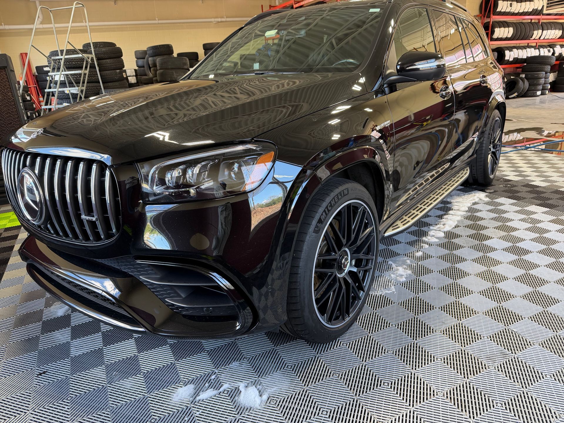 Black SUV in a showroom, angled front view on a patterned floor.