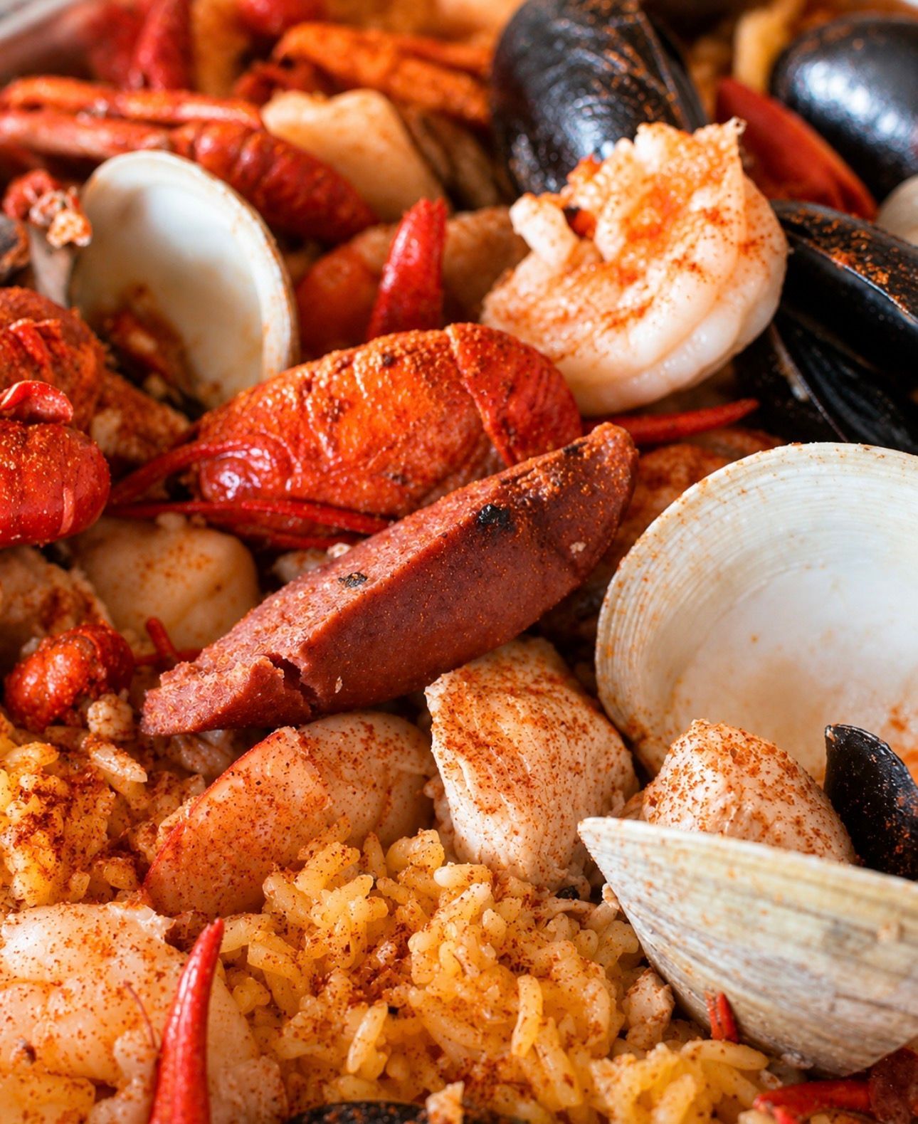 Spicy seafood boil with shrimp, crab, mussels, clams, and seasoned rice on a platter
