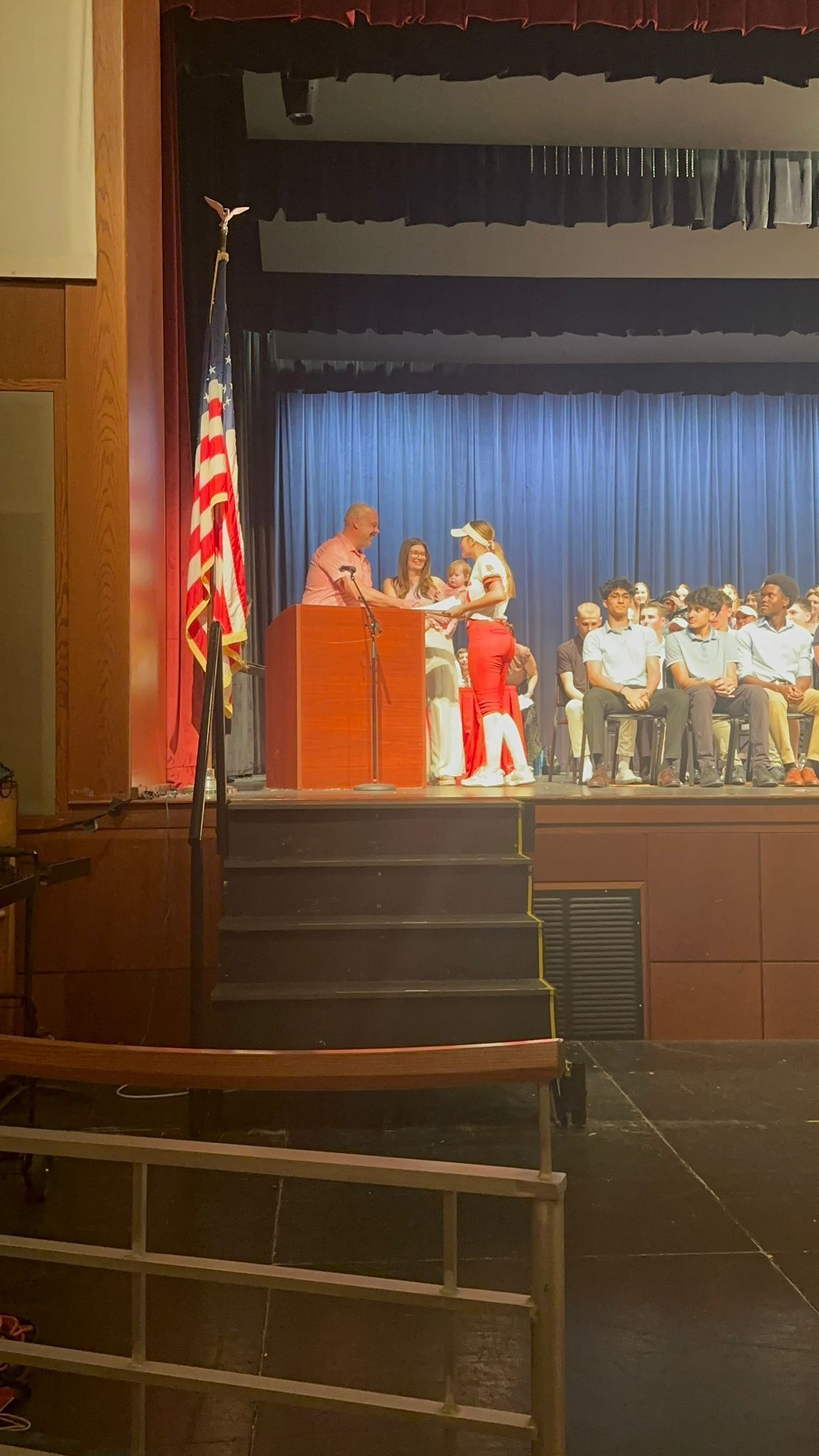 A man and a woman are standing at a podium on a stage.