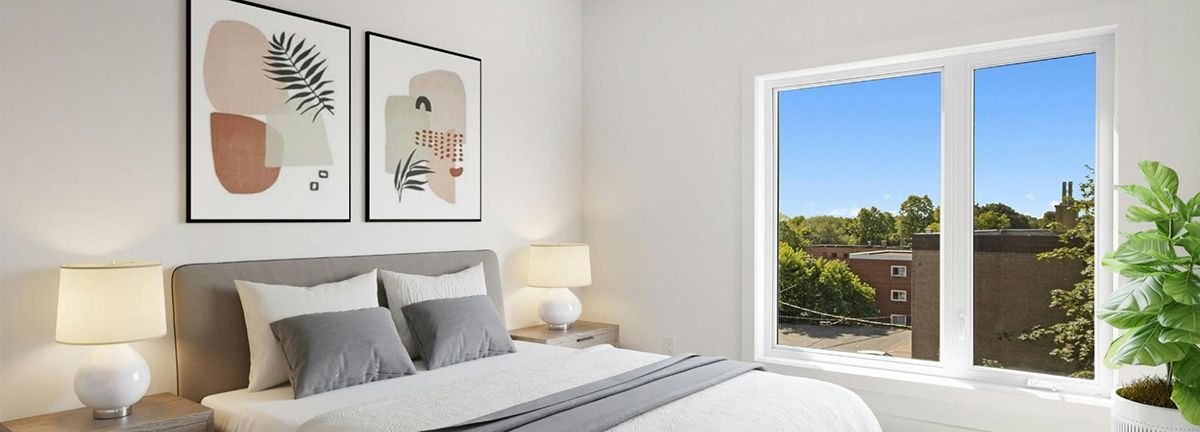 A bedroom with a large bed , two paintings on the wall and a large window.