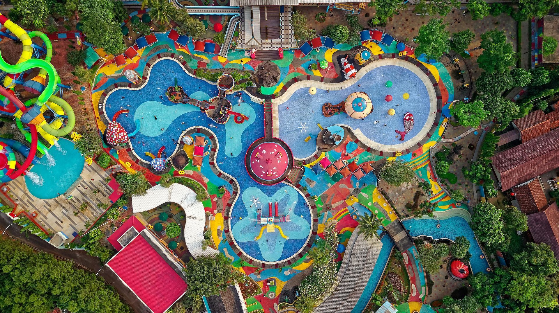 An aerial view of a water park filled with lots of swimming pools and water slides.