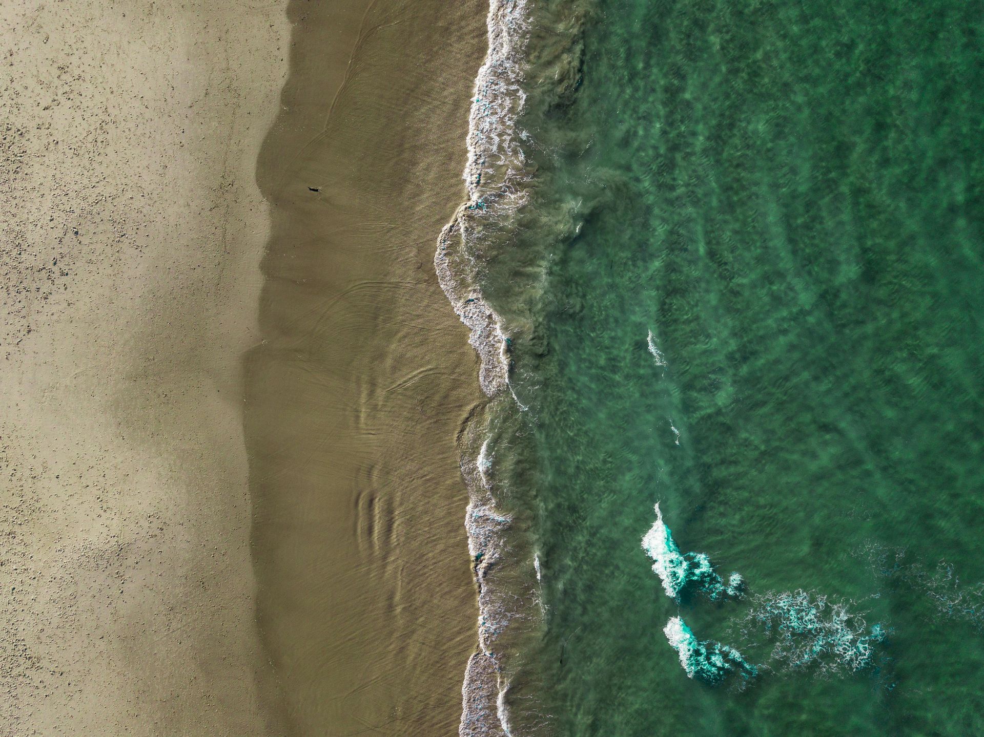 An aerial view of a beach and a body of water.