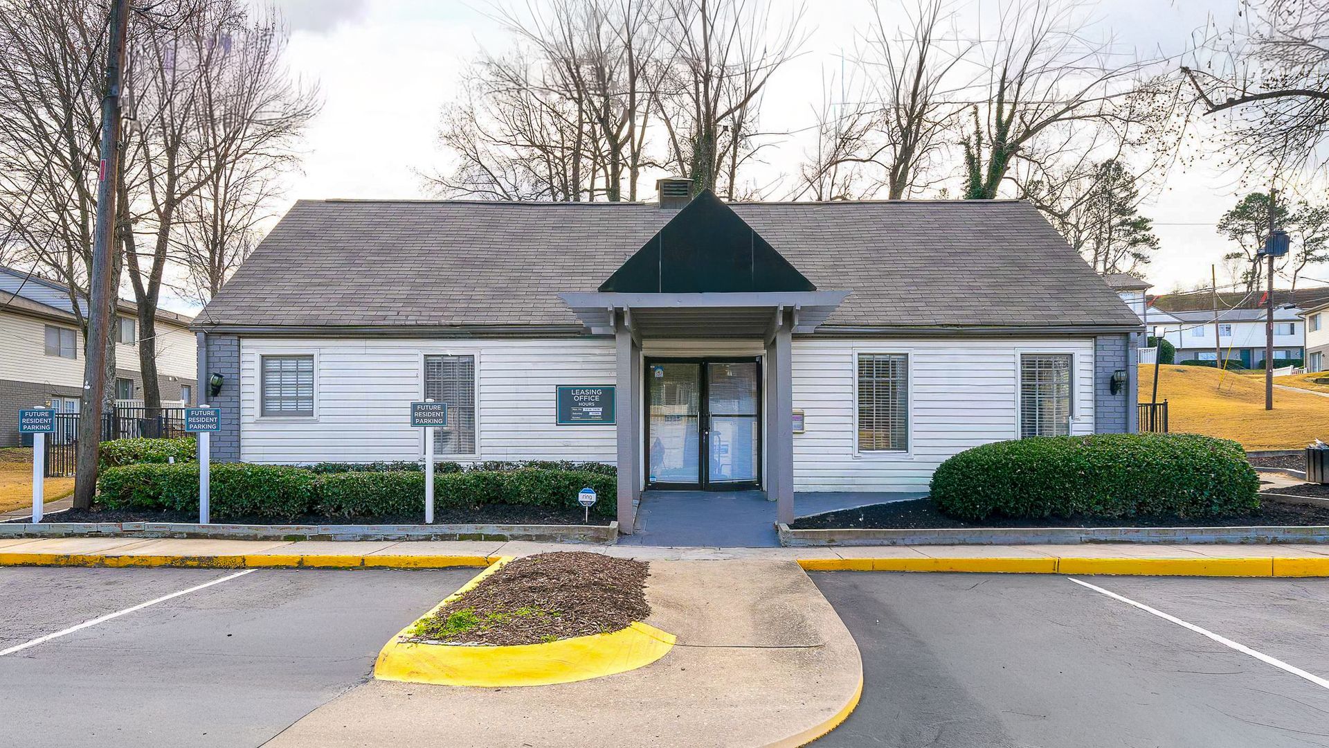 Exterior view of a white building with a blue golf cart parked outside.