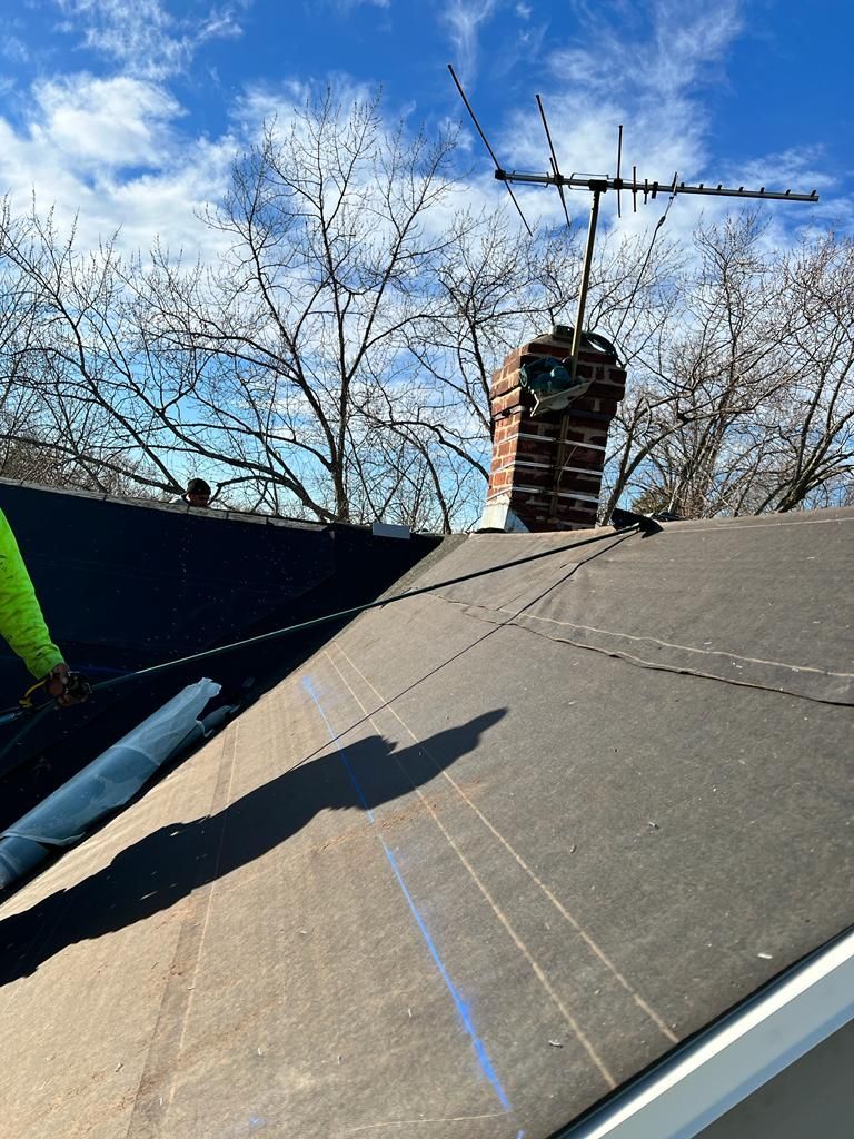 A roof with a chimney and an antenna on top of it.