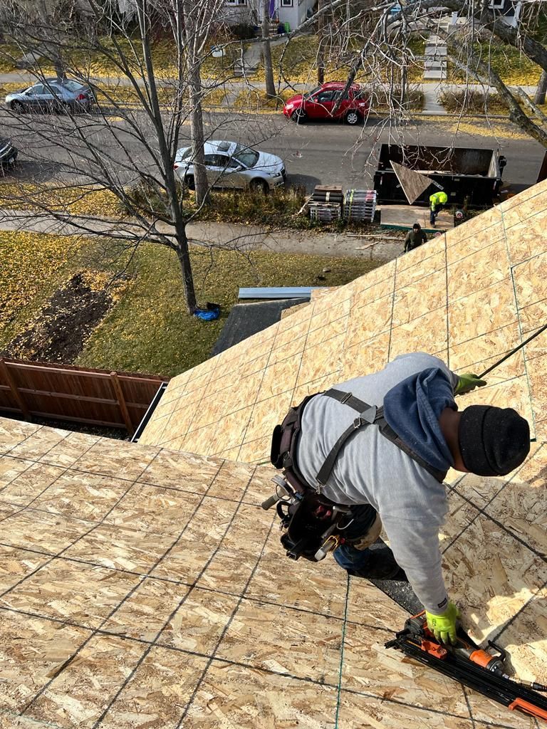A man is working on the roof of a house.