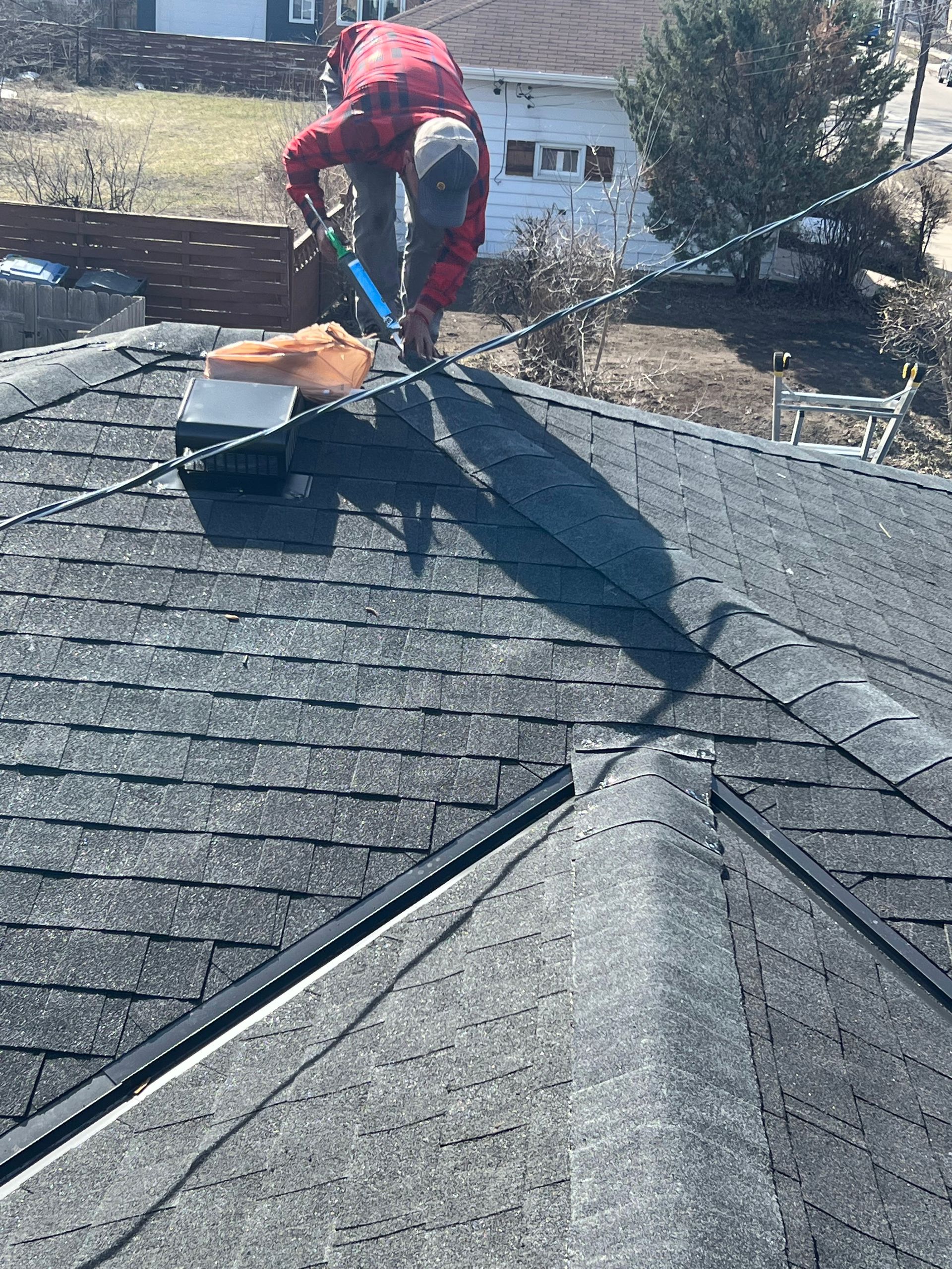 A man is working on the roof of a house.