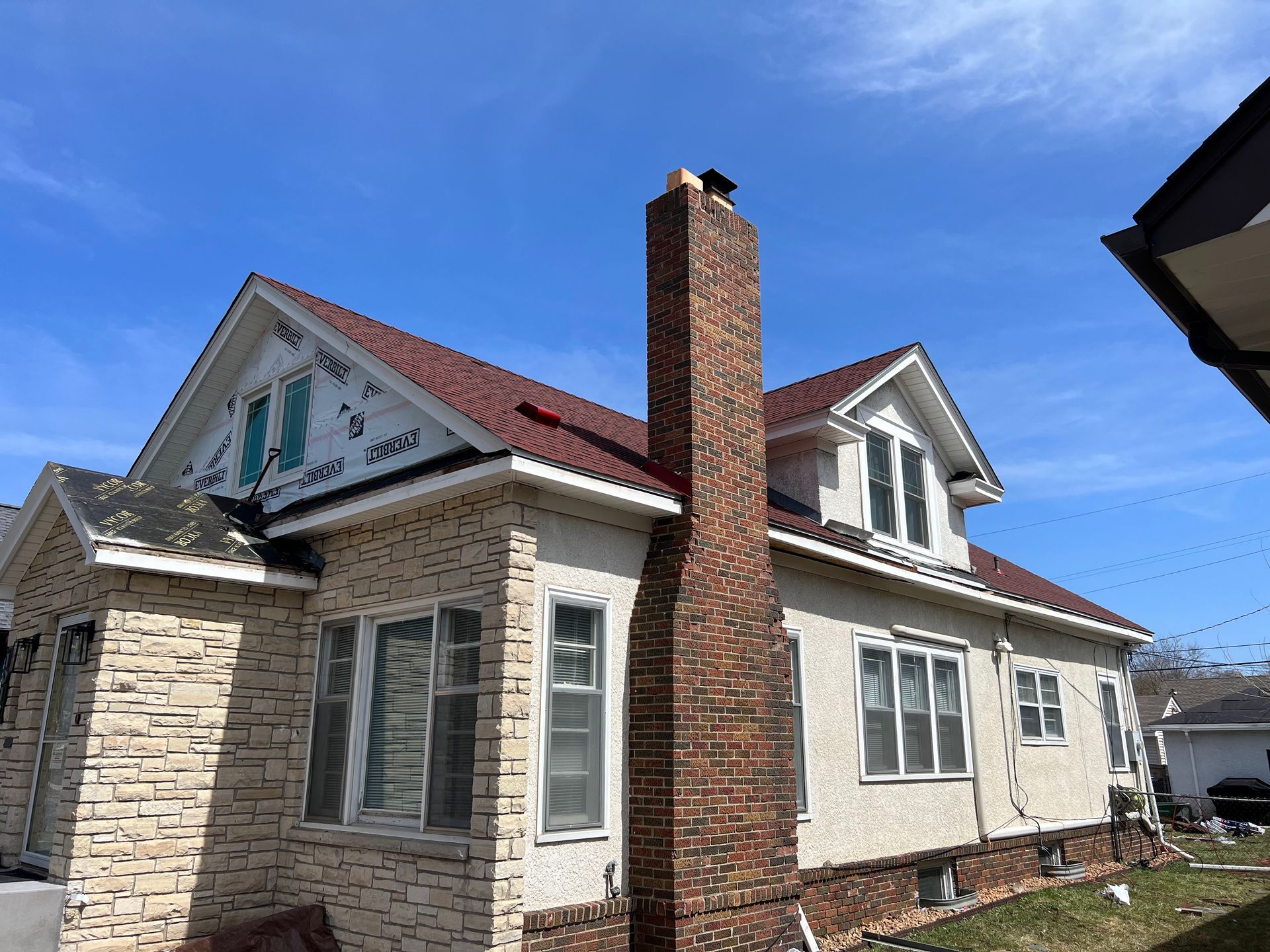 A large white house with a red roof and a chimney.