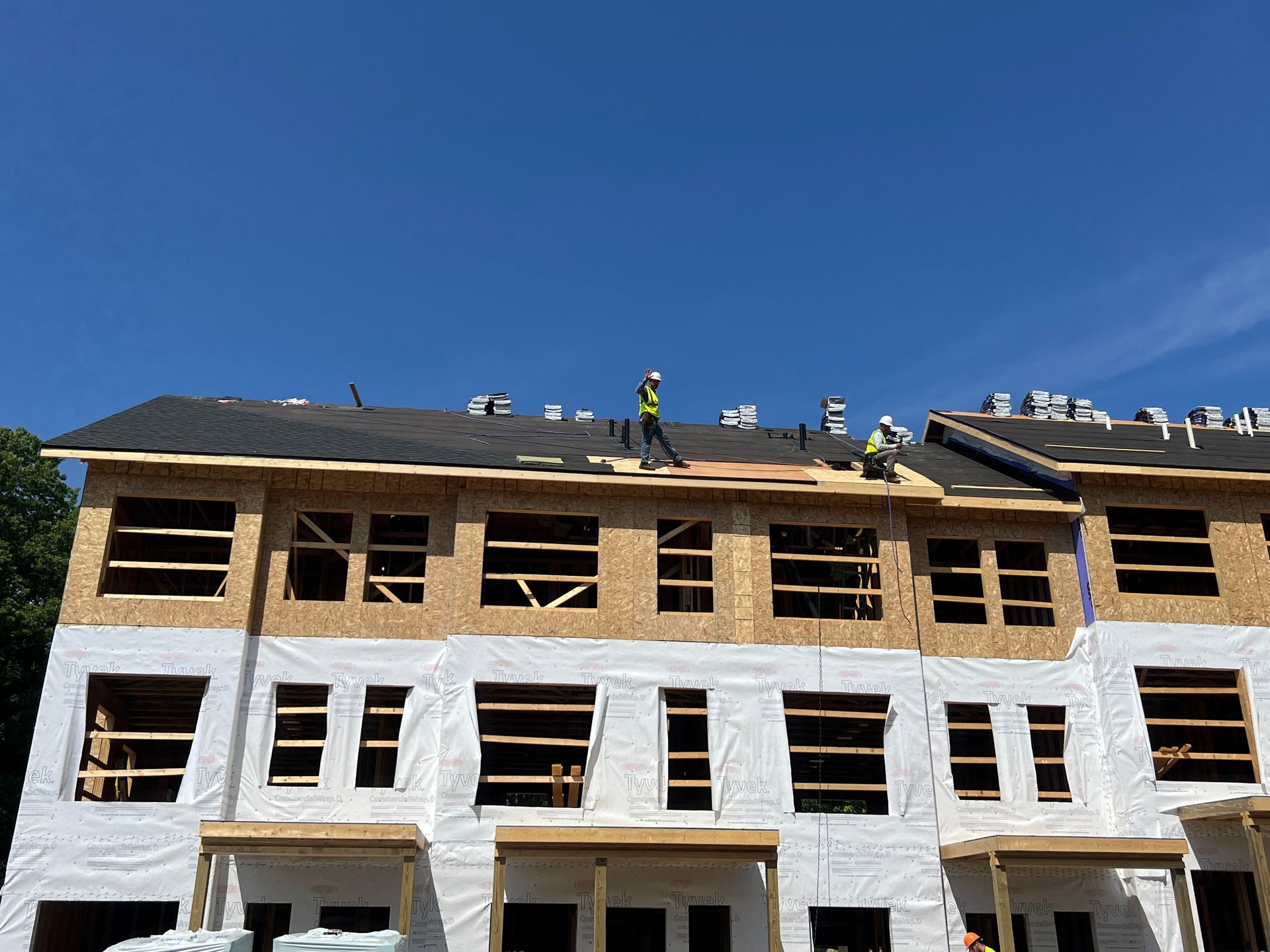 A group of construction workers are working on the roof of a building under construction.