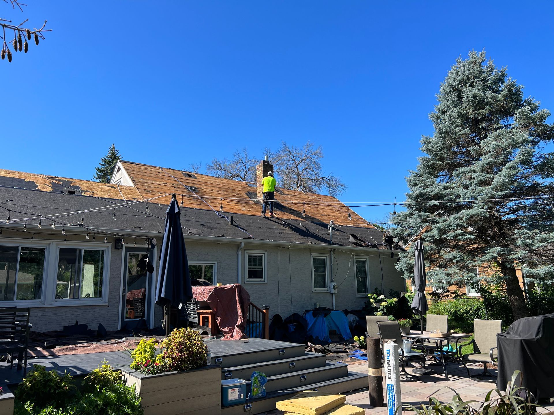 A man is standing on the roof of a house.
