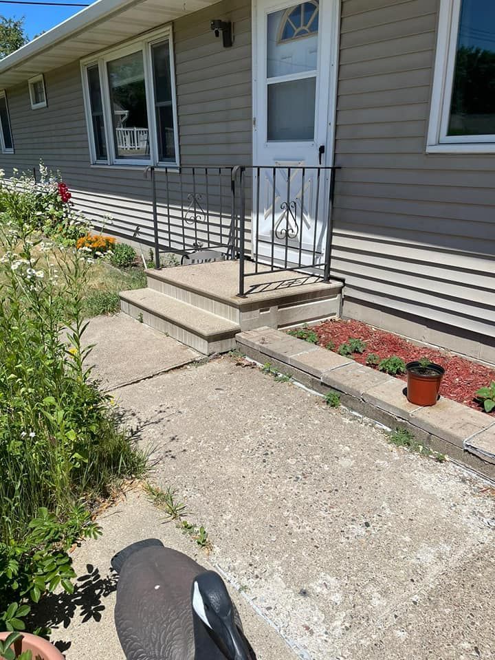 A house with a concrete walkway leading to the front door.