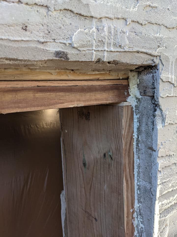 A wooden door is being built into a brick wall.