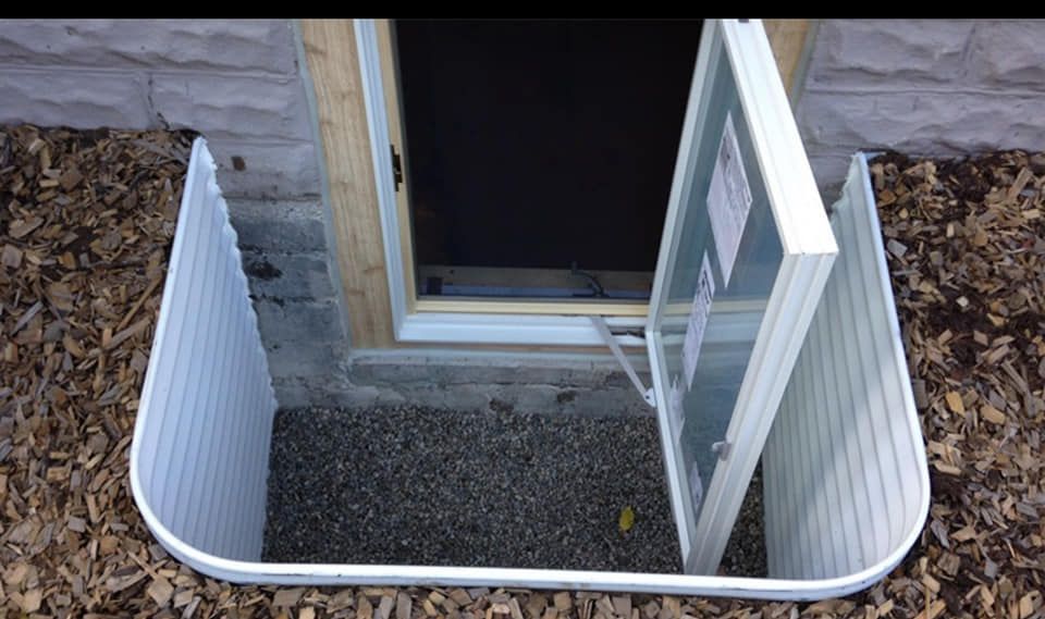 A window in a basement with the door open.
