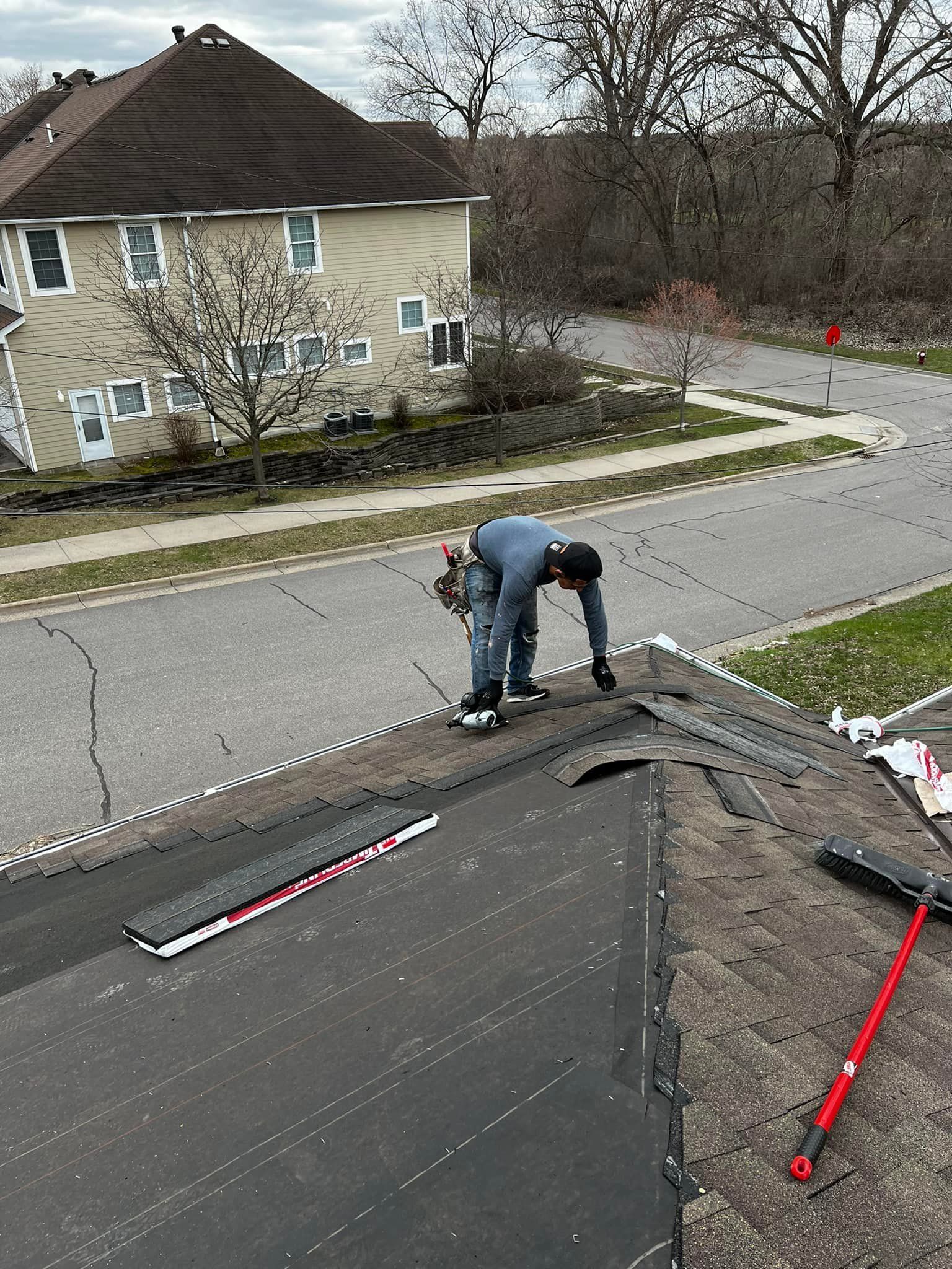 A man is working on the roof of a house.