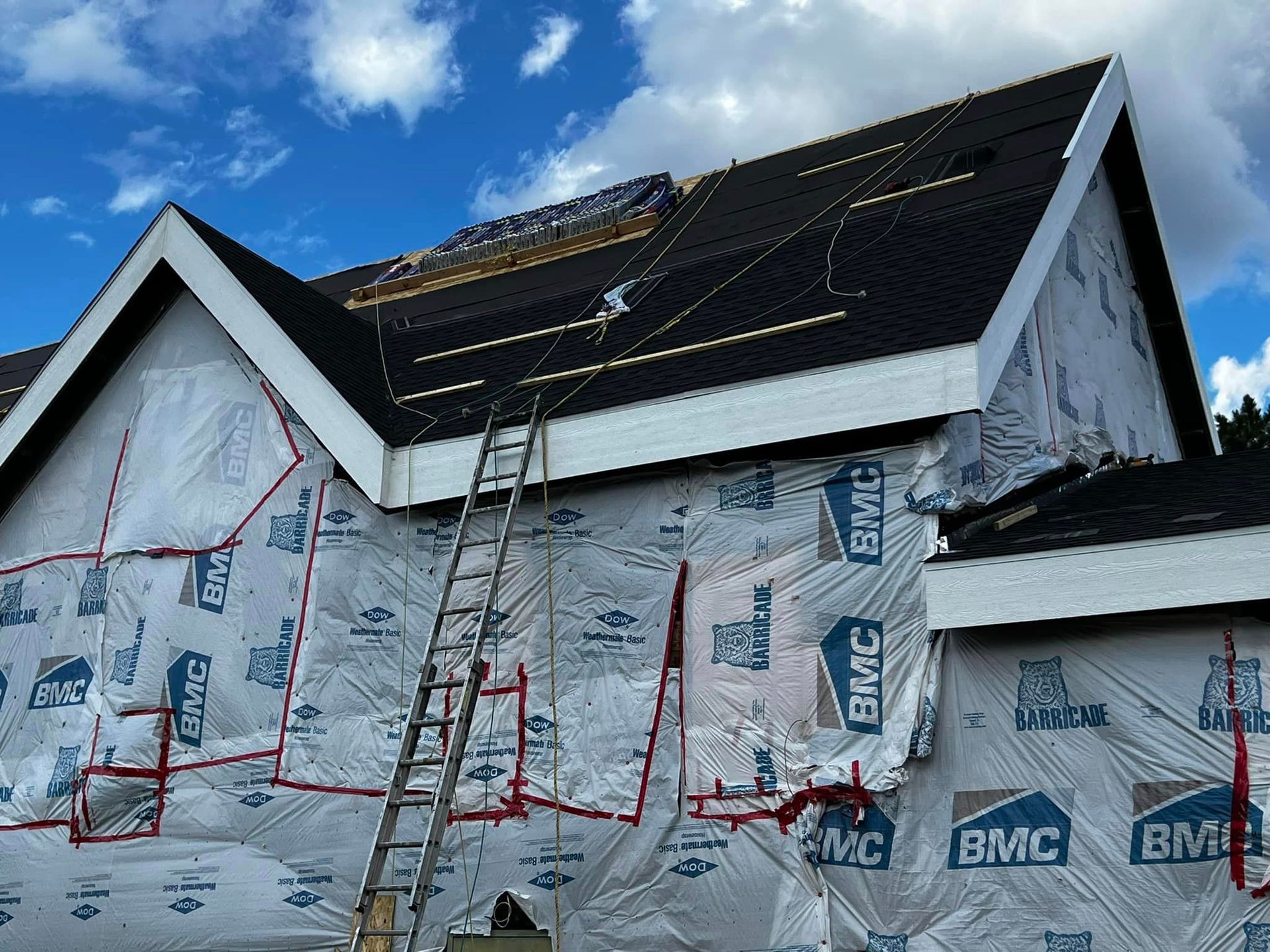 A ladder is attached to the side of a house that is being built