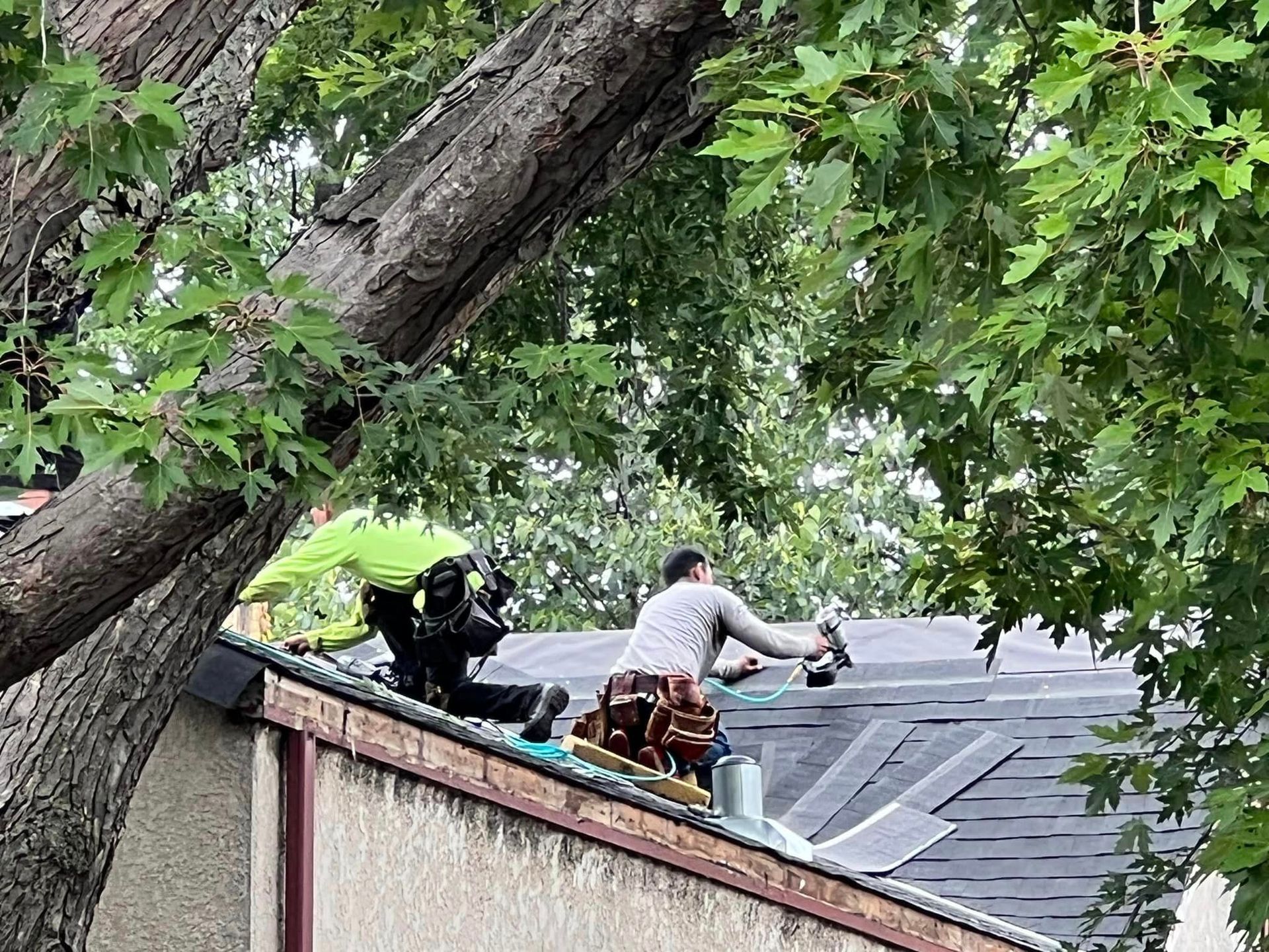 A group of men are working on the roof of a house.
