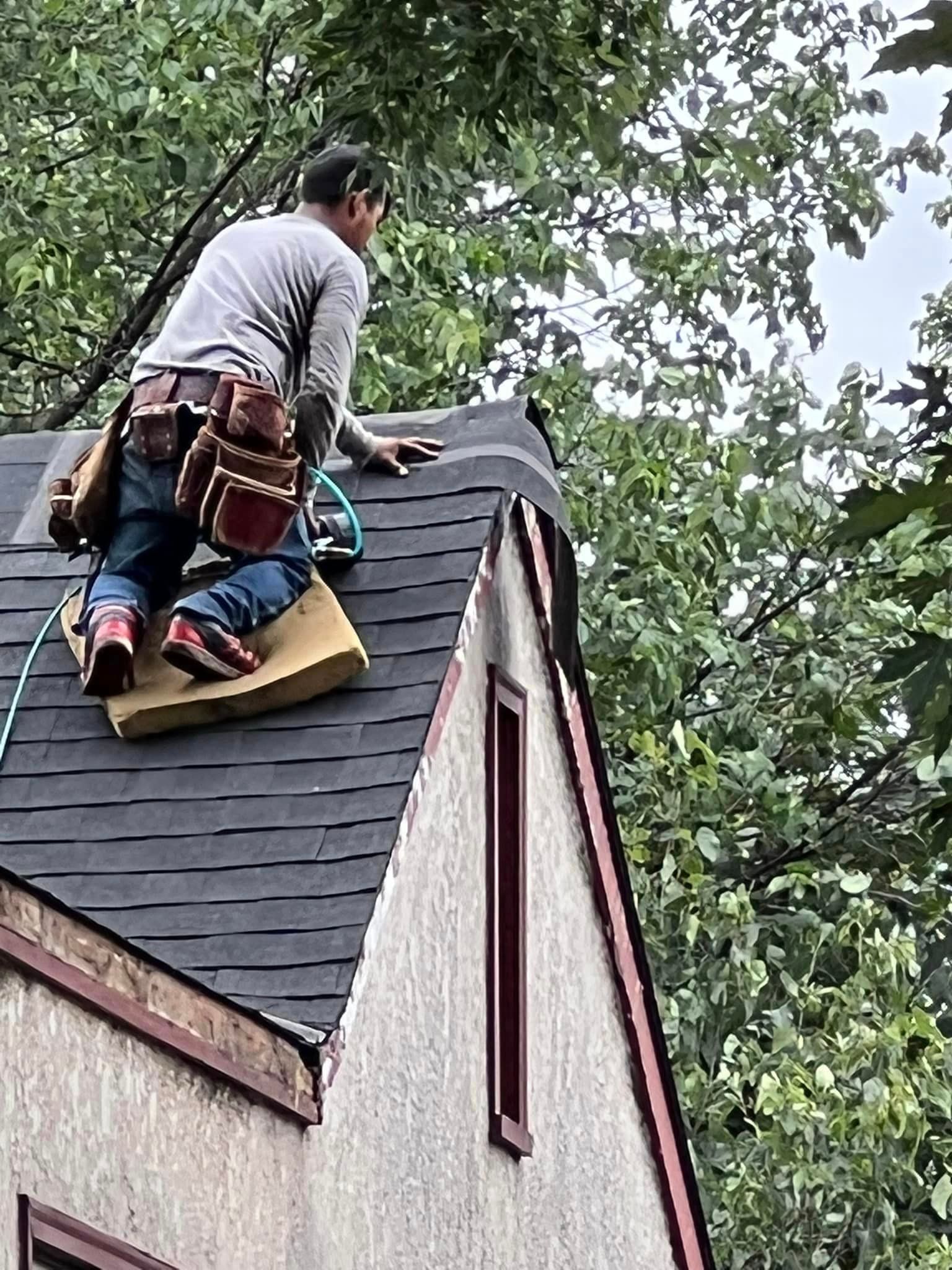 A man is working on the roof of a house.