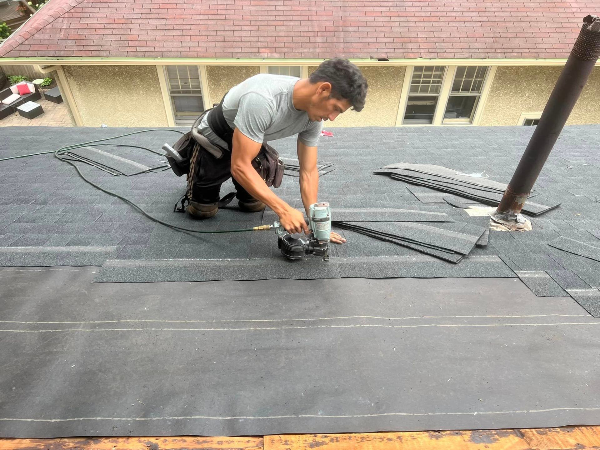 A man is working on the roof of a house.