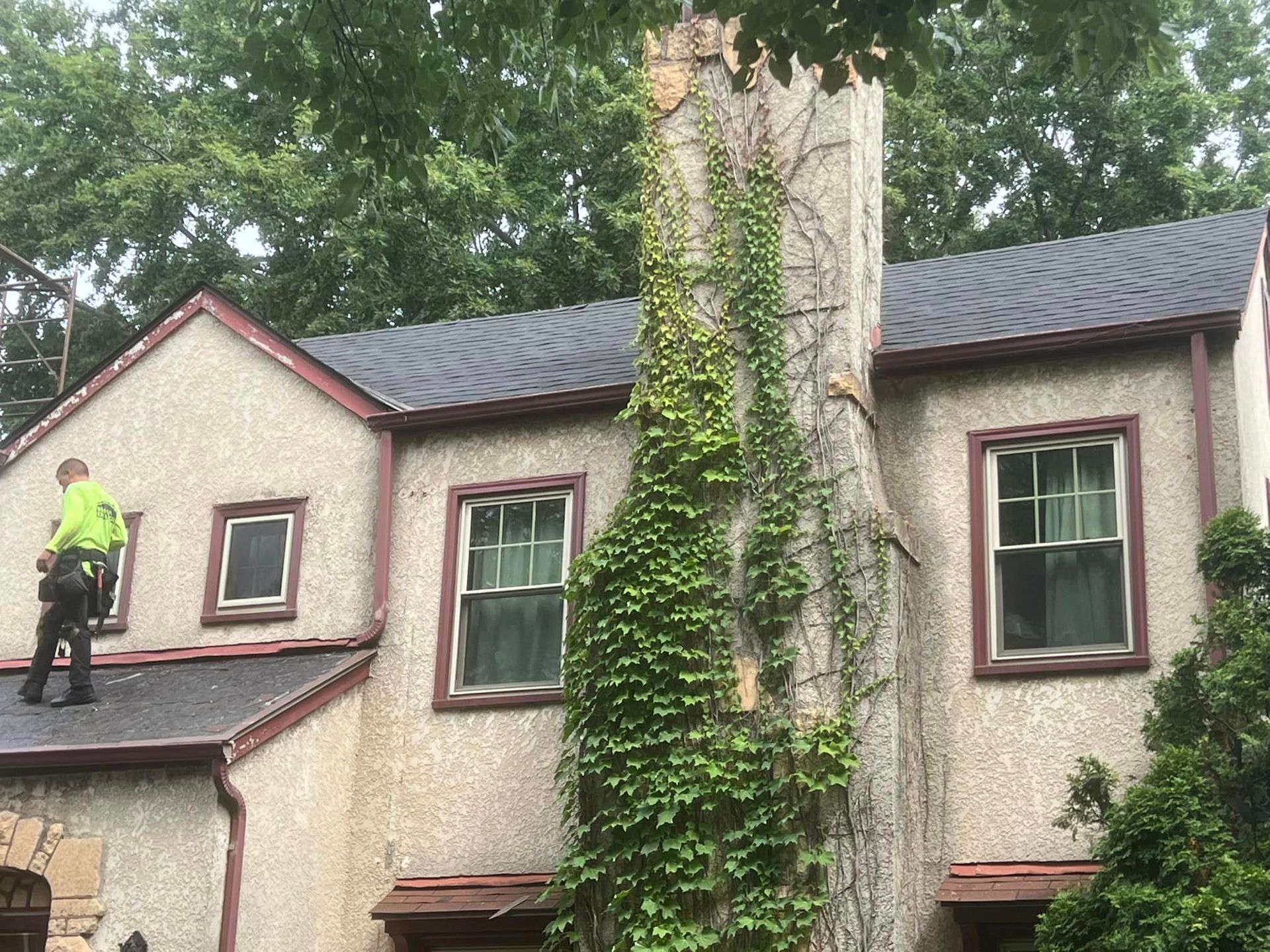 A man is standing on the roof of a house.