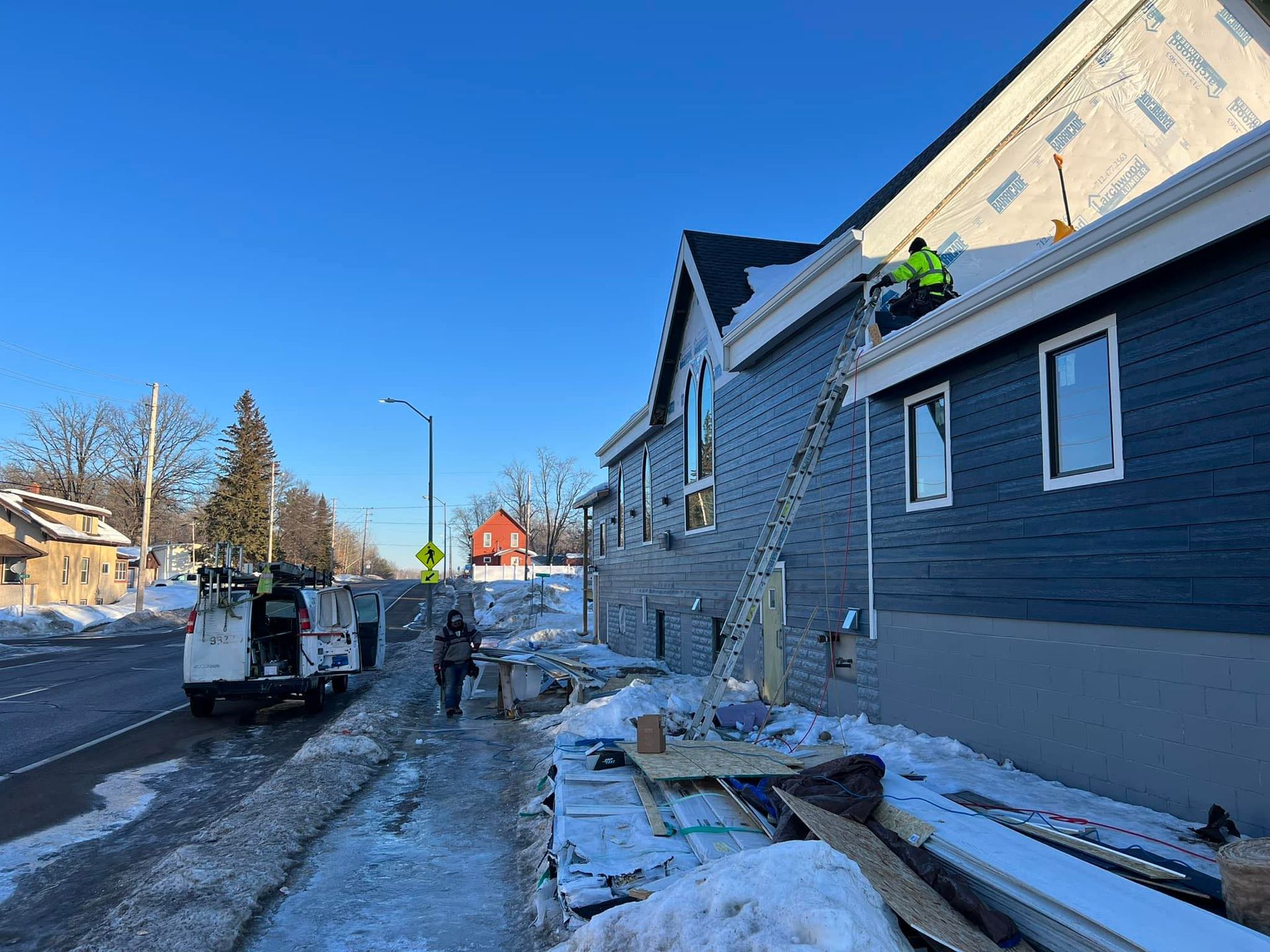 Two men are working on the roof of a house.