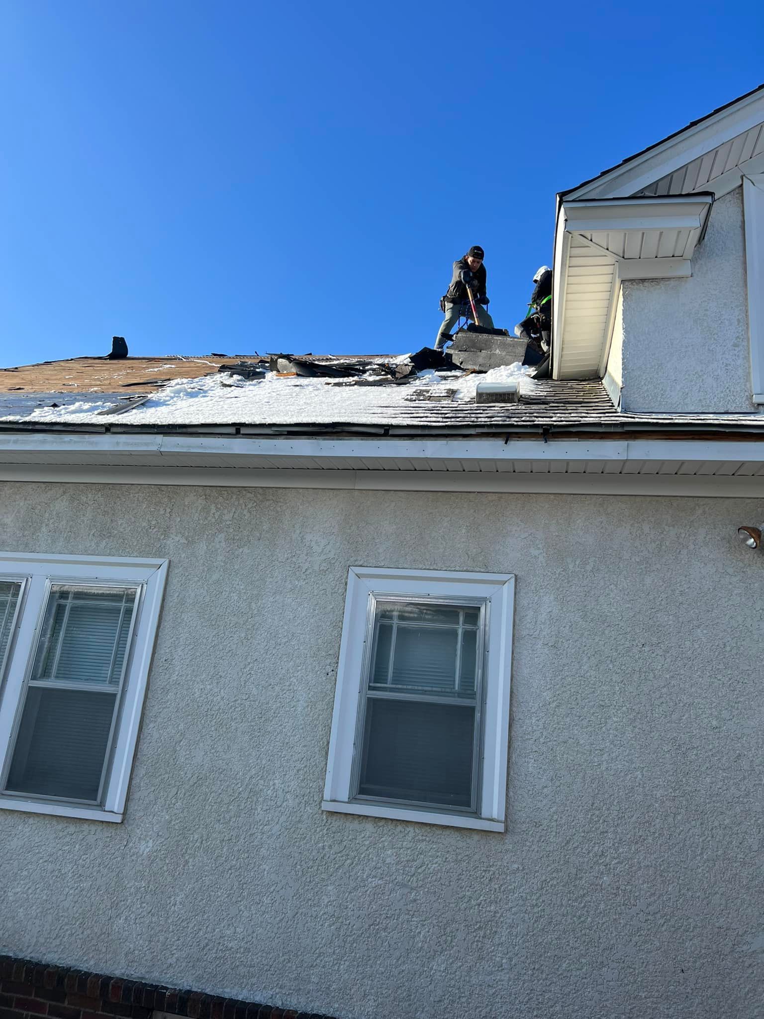 A man is working on the roof of a house.