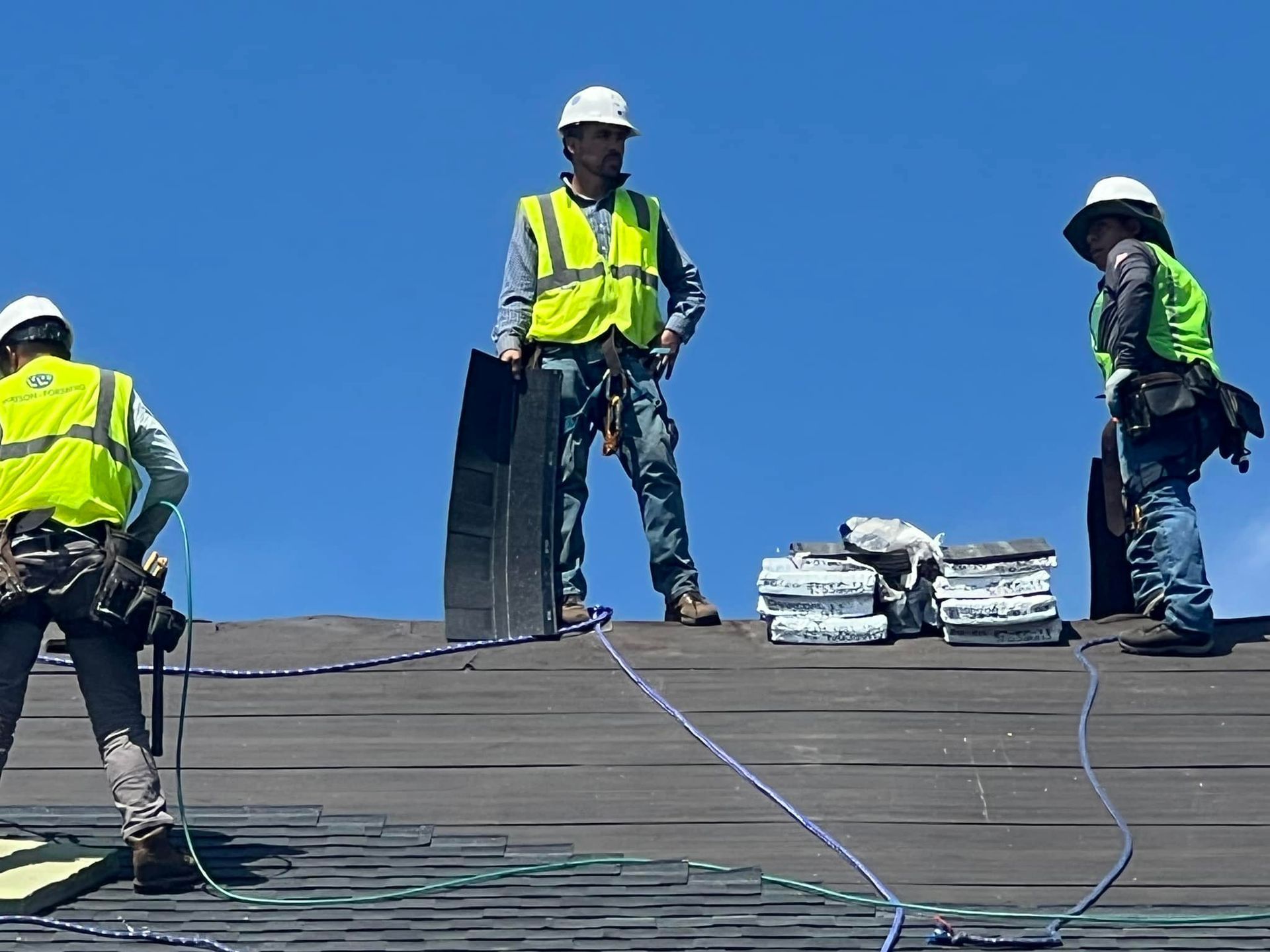 A group of construction workers are working on a roof
