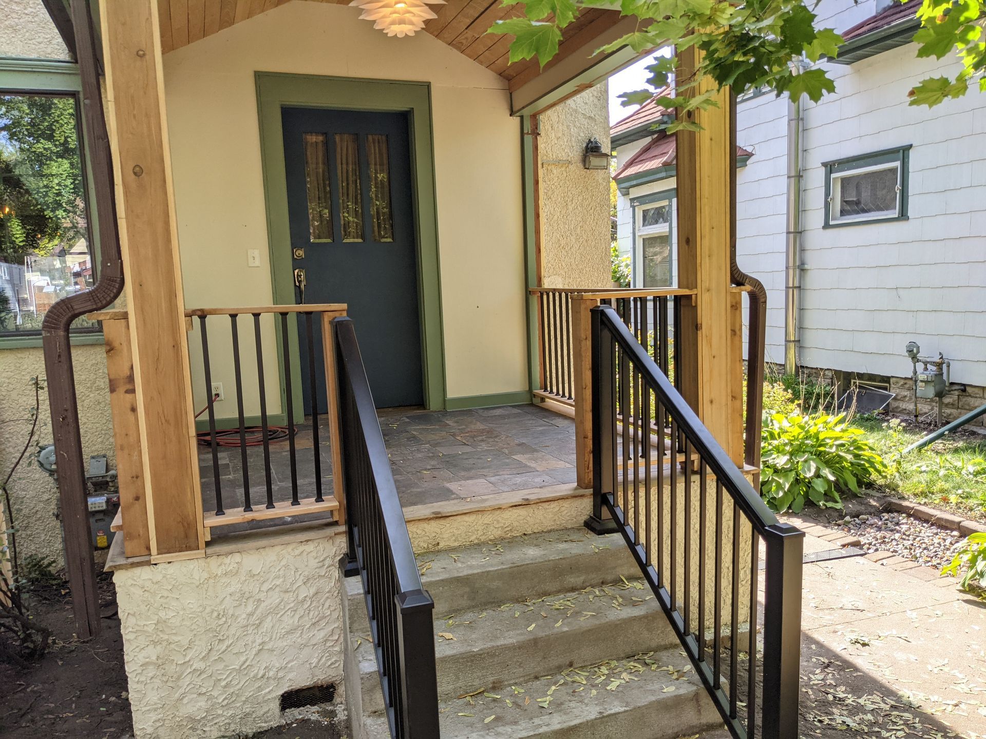A porch with stairs leading up to the front door of a house.