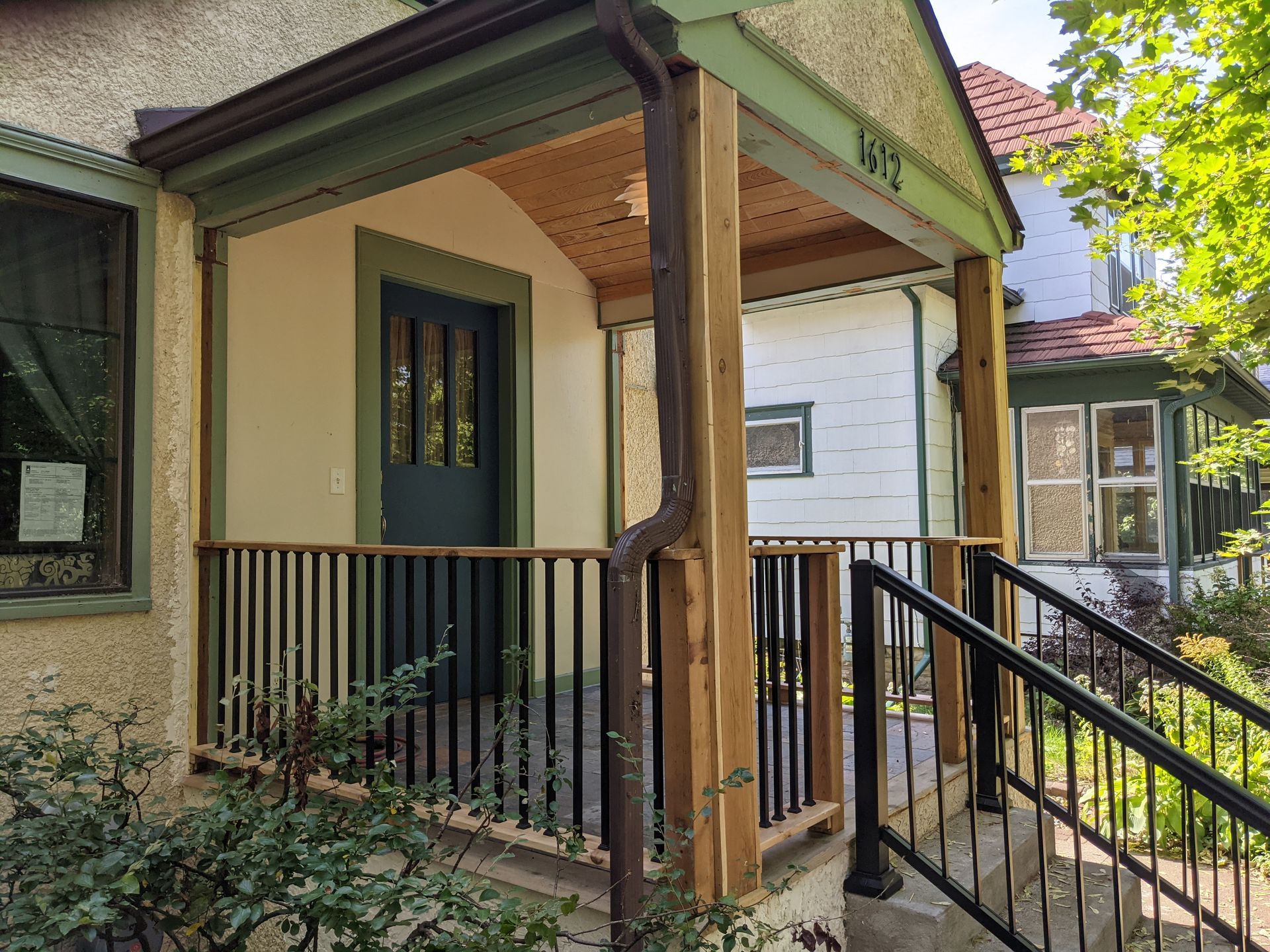 A house with a porch and stairs leading to it.