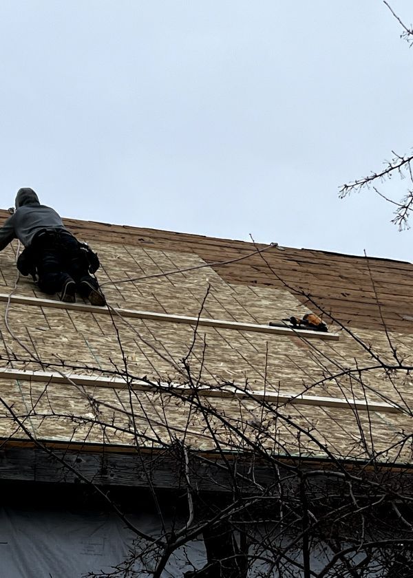 A man is working on the roof of a house.