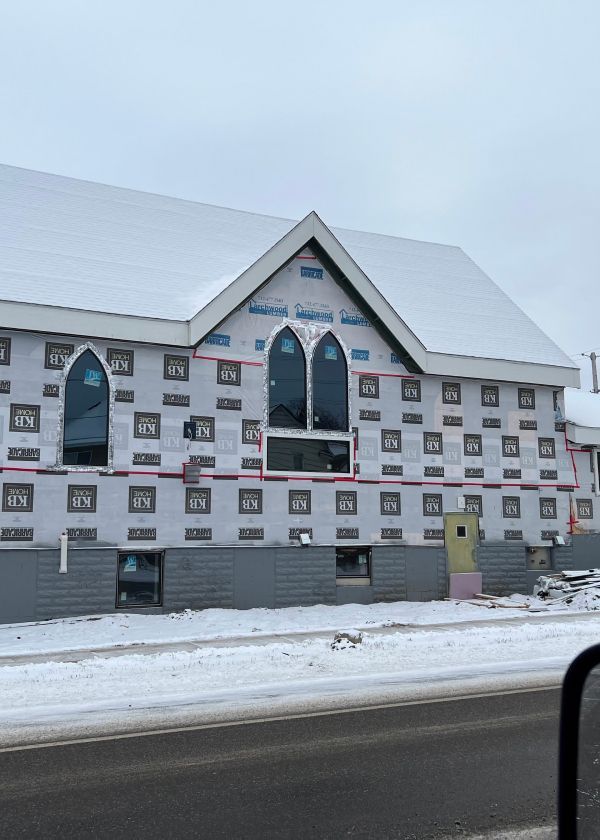 A building with a lot of windows is covered in snow.
