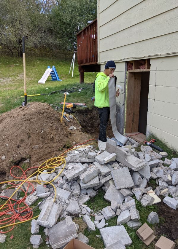 A man is working on the side of a house.