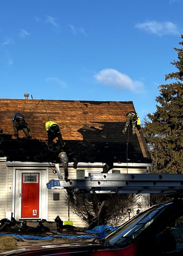 Two men are working on the roof of a house.