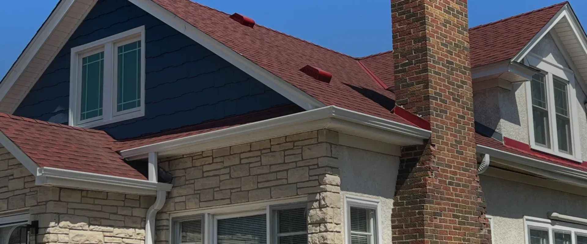 A large house with a red roof and a chimney.