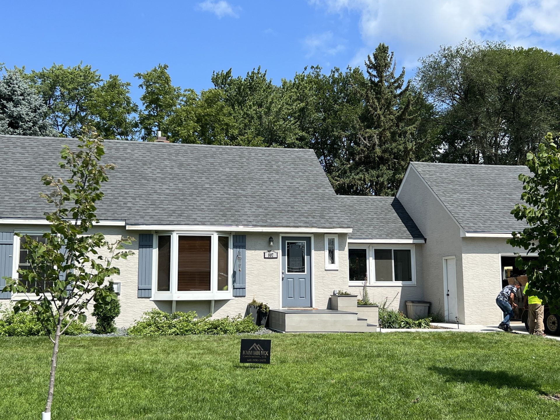 A house with a gray roof and a blue door