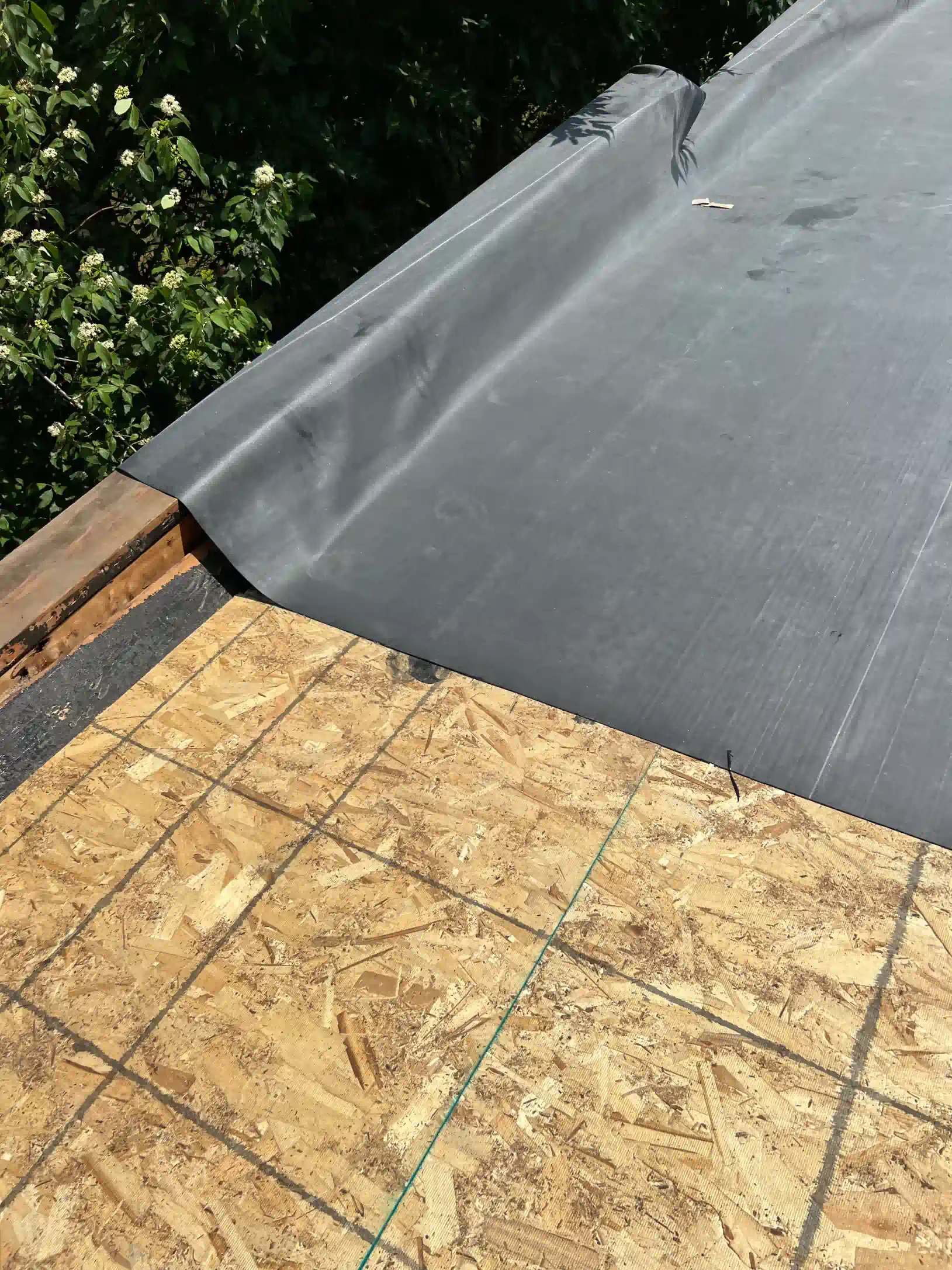A close up of a roof with a black tarp on it.